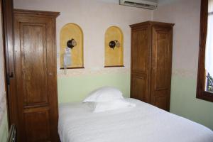 a bedroom with a bed and two wooden cabinets at La Marjolaine in Juan-les-Pins