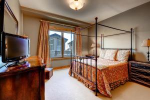 sypialnia z łóżkiem z baldachimem i telewizorem w obiekcie 5Br 5Ba Condo, Ski In Out In Arrowhead With Holidays Open! Condo w mieście Edwards