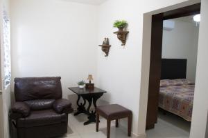 um quarto com uma cadeira, uma mesa e uma cama em Hotel Nápoles em Ciudad Obregón