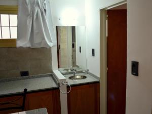 y baño con lavabo y espejo. en Vía Lavalle Suites en San Luis