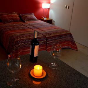 Zimmer mit einem Bett mit einer Flasche Wein und zwei Gläsern in der Unterkunft Vía Lavalle Suites in San Luis