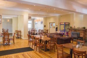 a restaurant with tables and chairs and a fireplace at Gardners Inn Hotel in Blackheath