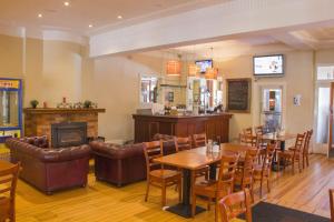 a restaurant with tables and chairs and a fireplace at Gardners Inn Hotel in Blackheath