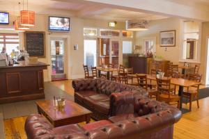 a restaurant with leather couches and tables and a bar at Gardners Inn Hotel in Blackheath +42 photos