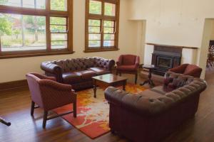 ein Wohnzimmer mit Ledermöbeln und Kamin in der Unterkunft Gardners Inn Hotel in Blackheath