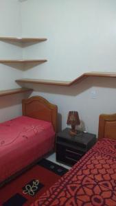 - une chambre avec deux lits et une table avec une lampe dans l'établissement Casa para aluguel de verão, à Torres
