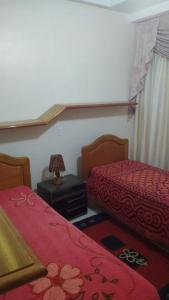 a bedroom with two beds and a lamp on a table at Casa para aluguel de verão in Torres