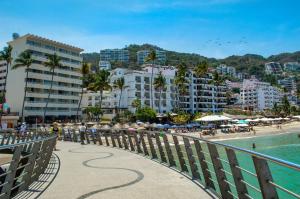 a group of people on a beach with buildings at Amapas Apartments Puerto Vallarta in Puerto Vallarta