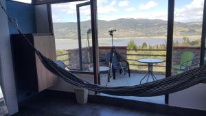 a hammock on a balcony with a view of a lake at Abadia de Tomine in Guatavita