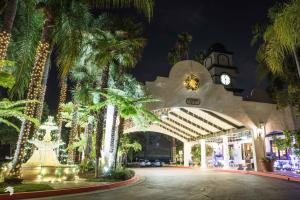 a building with palm trees and a clock tower at Vanllee Hotel in Covina