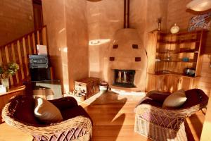 sala de estar con 2 sillas y chimenea en Amaroo Mountaintop Villa, en Katoomba