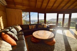 a living room with a leather couch and a table at Amaroo Mountaintop Villa in Katoomba