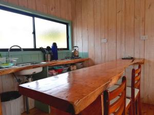 a large wooden table in a kitchen with a sink at Cabañas Paidahue Pichilemu in Pichilemu