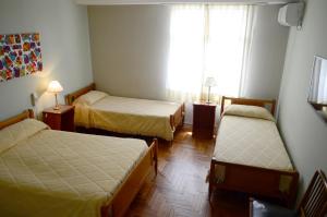 a room with two beds and a window at Hotel Ro Che Hil Tandil in Tandil
