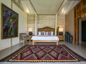 a bedroom with a bed and a rug at Villa Mannao by Villa Finder in Kerobokan