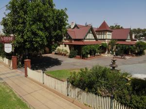 a large house with a white picket fence at The Lodge Outback Motel in Broken Hill