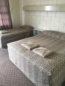 A bed or beds in a room at Monto Colonial Motor Inn