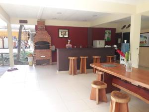 a kitchen with a table and stools and a fireplace at Chacara Santa Barbara in Manaus