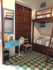 a bedroom with a desk and bunk beds at Hostal Cielito De María in Zacatecas