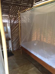 uma cama num quarto com uma rede mosquiteira em Backpacker's Hill Resort em San Vicente