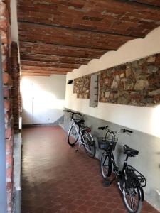 due biciclette parcheggiate in una stanza con muro di mattoni di Via Vittorio Emanuele 60 a Lucca
