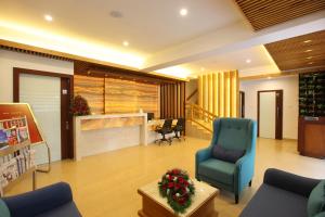 uma sala de espera com uma cadeira azul e uma mesa em Park Residency em Cochin