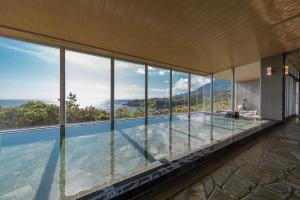a house with a swimming pool with glass windows at samana hotel Yakushima in Yakushima