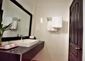 La salle de bains blanche est pourvue d'un lavabo et d'un miroir. dans l'établissement Sonalong Boutique Village & Resort, à Siem Reap