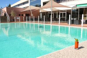 una grande piscina di fronte a un edificio di Best Western Plus Hotel Admiral a La Tour-de-Salvagny
