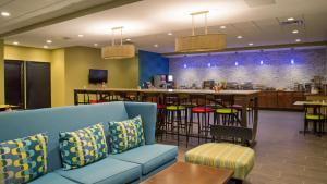 a waiting room with a couch and a bar at Albany Airport Inn in Albany