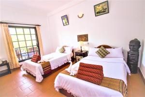 een slaapkamer met 2 bedden en een stoel. bij Sonalong Boutique Village & Resort in Siem Reap