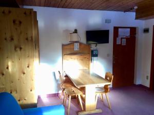 a wooden table and chairs in a room at Dolomiti Skyview in Carbonin