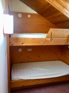 two bunk beds in a room with wooden walls at Dolomiti Skyview in Carbonin