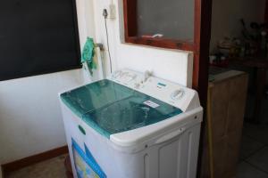 eine Waschmaschine mit einem Waschbecken darüber in der Unterkunft Saga Home in Ambalangoda