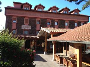 a large red brick building with tables and chairs at Hosteria San Emeterio in Isla
