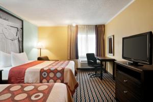a hotel room with two beds and a flat screen tv at Super 8 by Wyndham Des Moines in Des Moines