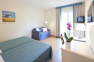 a bedroom with a bed and a couch and a window at Hotel Andreaneri in Marina di Pietrasanta