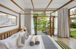a bedroom with a white bed with pillows at Bilin Tree House in Galle