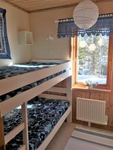 ein Schlafzimmer mit Etagenbetten und einem Fenster in der Unterkunft Holiday Home Fjätervålen Fjätstigen in Fjätervålen