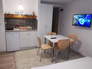 a small kitchen with a white table and chairs at Vila Jelena in Crni Vrh
