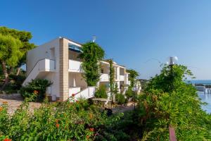 a building on the beach with trees and flowers at Villaggio Passo Dell'Arciprete in Vieste
