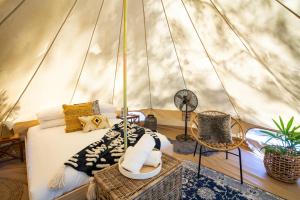 a bedroom in a yurt with a bed and chairs at Castlemaine Gardens Luxury Glamping in Castlemaine