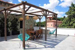a wooden pergola on a patio with a table and chairs at Residenza storica con vista panoramica in Perugia
