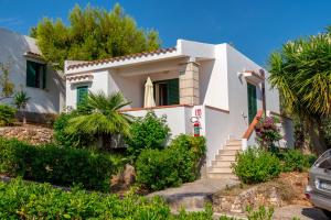 a white house with palm trees in front of it at Villaggio Passo Dell'Arciprete in Vieste