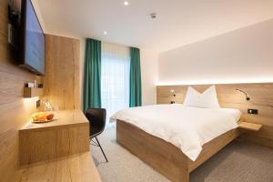 a hotel room with a bed and a television at Hotel Vaduzerhof by b-smart in Vaduz