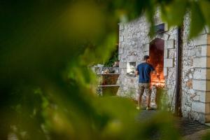 a man standing in front of a brick oven at Villaggio Passo Dell'Arciprete in Vieste