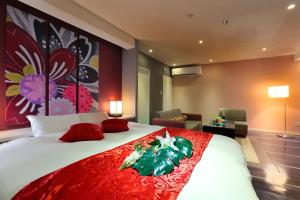 a bedroom with a large bed with red pillows at HOTEL 小粋 -coiki- in Hiroshima