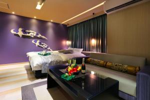 um quarto de hotel com uma cama e um sofá em HOTEL 小粋 -coiki- em Hiroshima