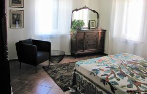 1 dormitorio con cama, silla y espejo en Residenza storica con vista panoramica, en Perugia