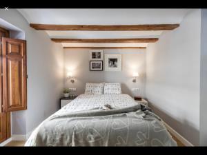 um quarto com uma cama branca e um tecto de madeira em WeRentVLC - Encantador Loft Casco Antiguo em Valência